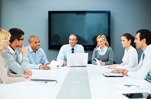 group of business people sitting around a meeting table